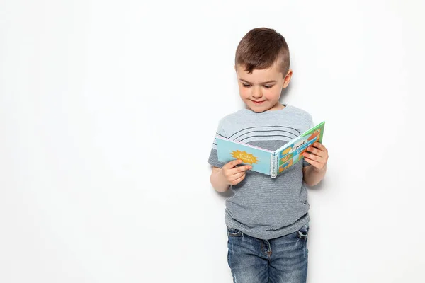 Niedlicher kleiner Junge liest Buch auf weißem Hintergrund, Platz für Text — Stockfoto