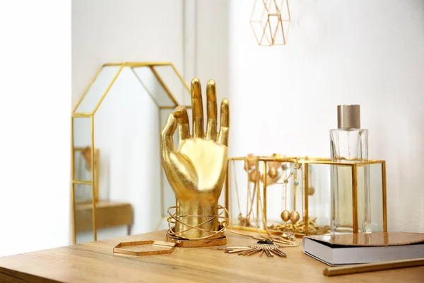 Komposition mit goldenen Accessoires auf Schminktisch in der Nähe der weißen Wand — Stockfoto