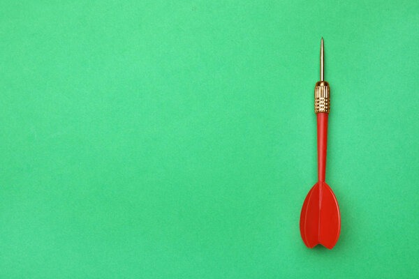 Красный дротик стрелка на зеленом фоне, вид сверху с пространством для текста
