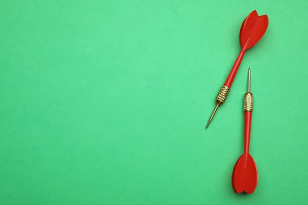 Setas de dardo vermelho no fundo verde, flat lay com espaço para texto — Fotografia de Stock