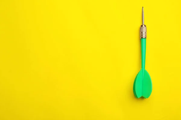 Groene Dart pijl op gele achtergrond, bovenaanzicht met ruimte voor tekst — Stockfoto