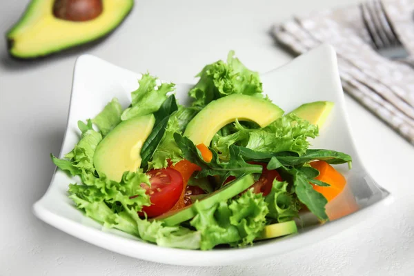 Deliciosa ensalada de aguacate en tazón sobre mesa blanca —  Fotos de Stock