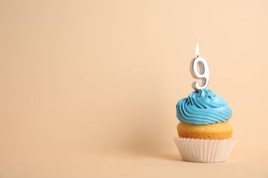 Bej arka plan üzerinde dokuz numaralı mum ile Doğum günü cupcake, metin için alan