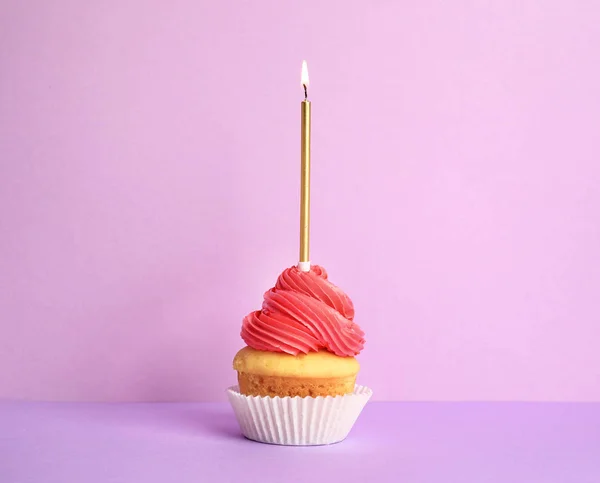 Mor arka plan üzerinde mum ile Doğum günü cupcake — Stok fotoğraf
