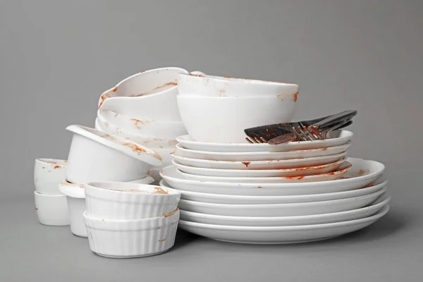 Set of dirty dishes on grey background
