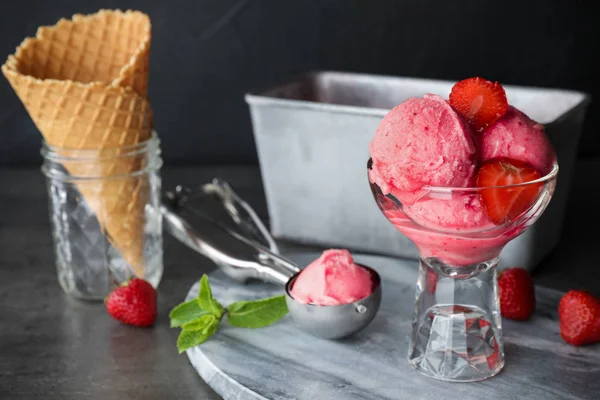 Delicious strawberry ice cream in dessert bowl served on grey table