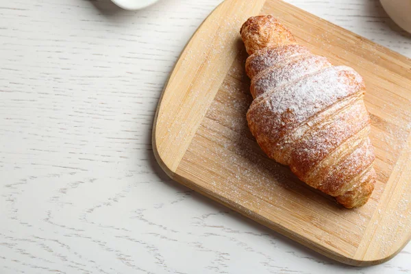 Tafel mit leckerem Croissant, Puderzucker und Platz für Text auf weißem Holztisch, darüber Ansicht. französisches Gebäck — Stockfoto