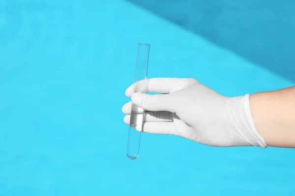 Mujer sosteniendo tubo de vidrio con muestra de agua de la piscina para comprobar el nivel de PH al aire libre, primer plano —  Fotos de Stock