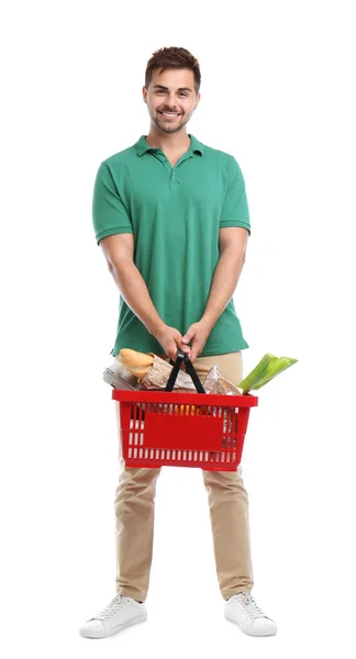 Junger Mann mit Einkaufskorb voller Produkte auf weißem Grund — Stockfoto