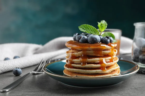 Delicious pancakes with fresh blueberries and syrup on grey table — Stock Photo, Image
