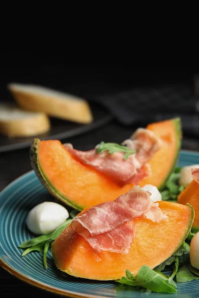 Frische Melone mit Schinken, Mozzarella und Rucola auf dem Tisch — Stockfoto