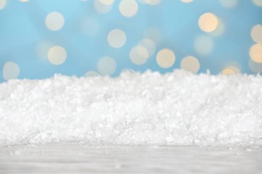 Mavi arka plana karşı ahşap yüzeyde kar yığını. Noel sezonu