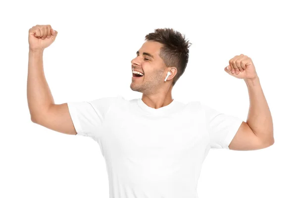 Ευτυχισμένος νέος άνθρωπος ακούγοντας μουσική μέσω ασύρματων ακουστικών σε λευκό φόντο — Φωτογραφία Αρχείου