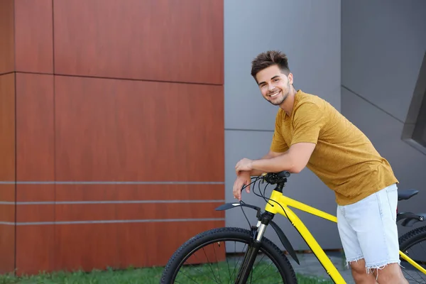 Pohledný mladý muž s bicykl na městské ulici. Místo pro text — Stock fotografie