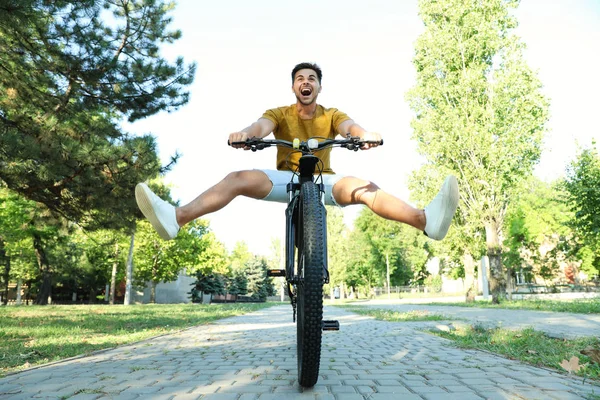Pohledný mladý muž s bicykl v městském parku, pohled na nízký úhel — Stock fotografie