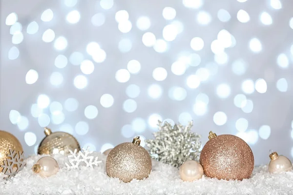 Kerst decoratie op sneeuw tegen onscherpe achtergrond — Stockfoto