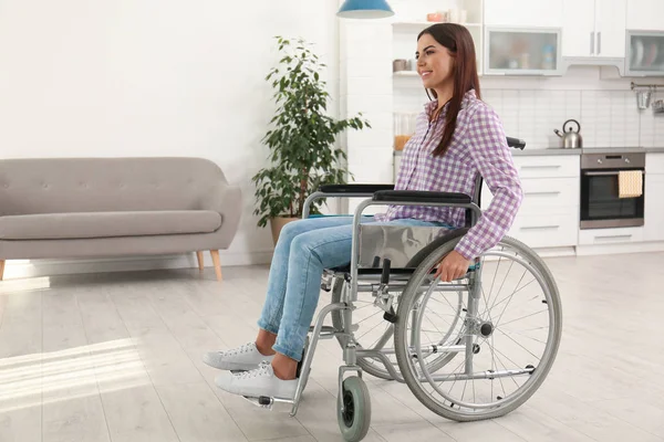 Молодая женщина сидит в современном инвалидном кресле в помещении — стоковое фото