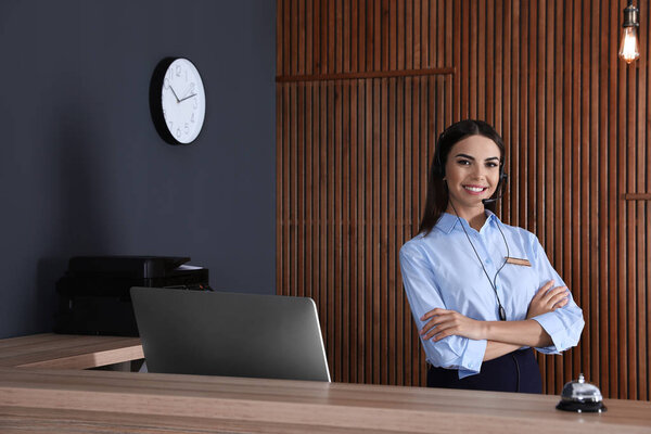 Portrait of receptionist with headset at desk in lobby