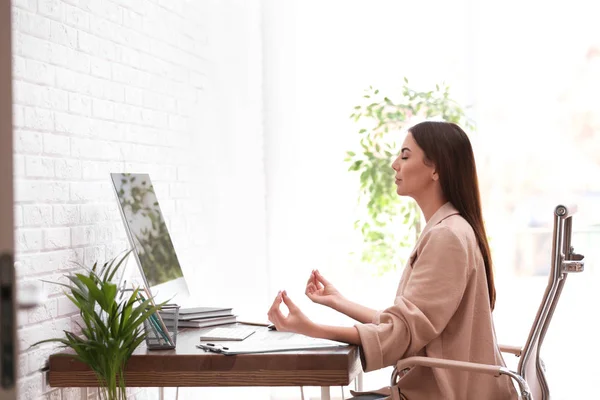 Jonge zakenvrouw mediteren op de werkplek. Zen concept — Stockfoto
