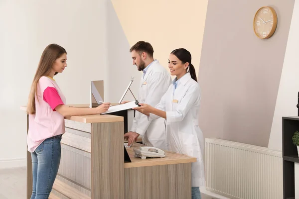 Professionele receptionisten werken met de patiënt bij het Bureau in de moderne kliniek — Stockfoto