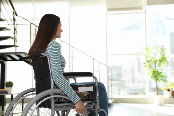 Jonge vrouw in rolstoel binnenshuis. Ruimte voor tekst — Stockfoto
