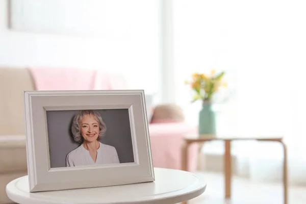 Ingelijste portret van senior vrouw op tafel binnenshuis. Ruimte voor tekst — Stockfoto
