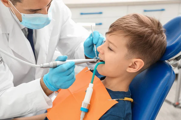 Dentista profesional que trabaja con un niño pequeño en la clínica —  Fotos de Stock