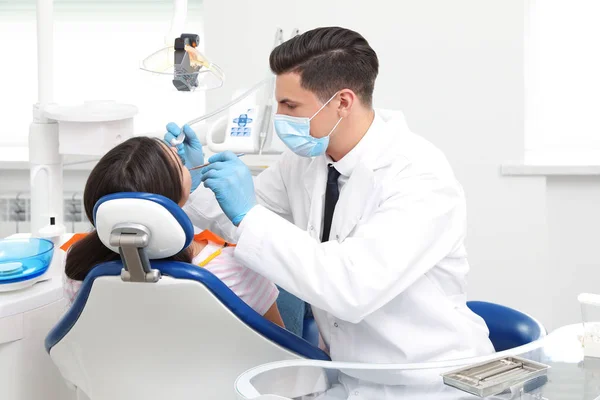 Professional dentist working with patient in clinic — Stock Photo, Image