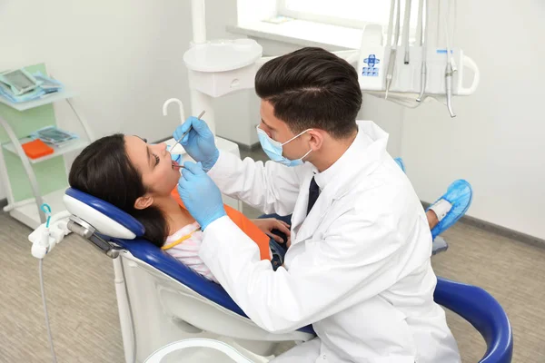 Professioneller Zahnarzt arbeitet mit Patient in Klinik — Stockfoto