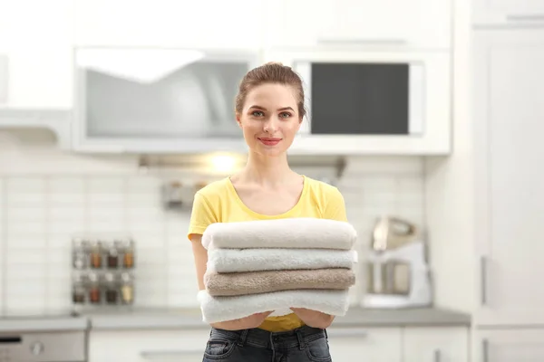 Donna che tiene asciugamani puliti piegati in cucina. Giorno di lavanderia — Foto Stock