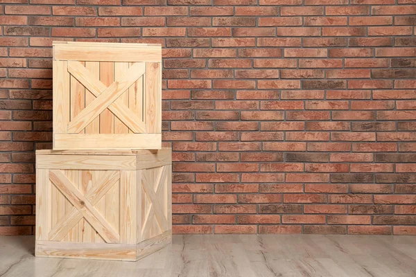 Wooden crates on floor at brick wall. Space for text