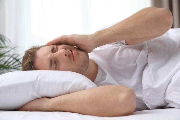 Knappe jonge man liggend onder deken thuis. Bedtime — Stockfoto
