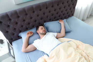 Yakışıklı adam evde yastık üzerinde uyuyor, yukarıdan görünümü. Yat -madan