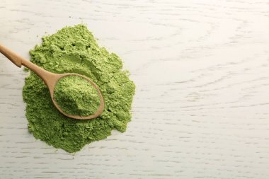 Beyaz ahşap masa üzerinde buğday çim tozu ile Kaşık, üst görünümü. Metin için alan