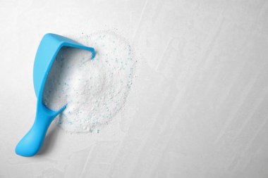 Hafif arka planda çamaşır deterjanı ile kepçe ölçümü, üst görünüm. Metin için alan