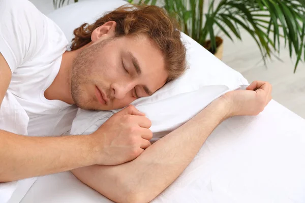 Un joven guapo durmiendo en la almohada por la mañana. Hora de dormir —  Fotos de Stock