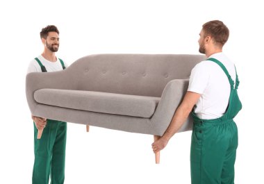 Beyaz üzerinde izole edilmiş kanepe taşıyan genç işçiler. Taşıma hizmeti