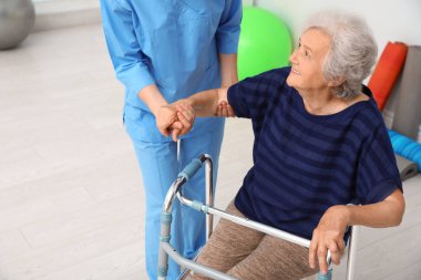 Kapıda yürüyen çerçeve ile yaşlı kadın yardım Bakıcısı