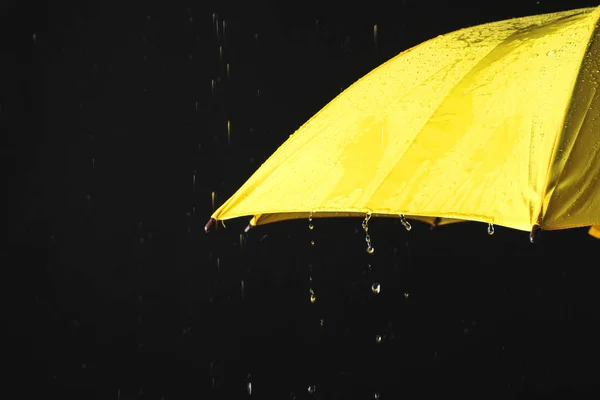검은 배경, 클로즈업에 대한 비 아래 노란색 우산을 열었습니다. — 스톡 사진