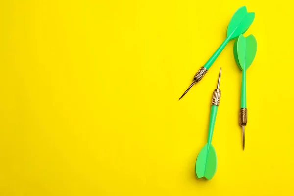 Flechas de dardo verde sobre fondo amarillo, plano con espacio para el texto —  Fotos de Stock