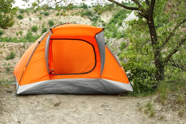 Modern camping tent near tree in wilderness — Stock Photo, Image