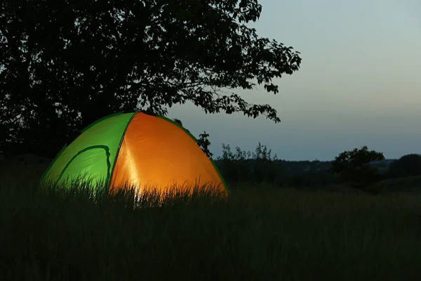 Tienda moderna iluminada desde el interior en el desierto por la noche, espacio para el texto. Camping nocturno — Foto de Stock