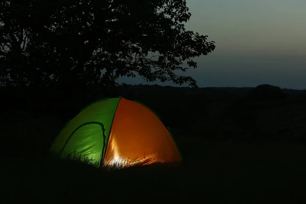 Tenda moderna iluminada de dentro em deserto à noite, espaço para texto. Acampamento noturno — Fotografia de Stock