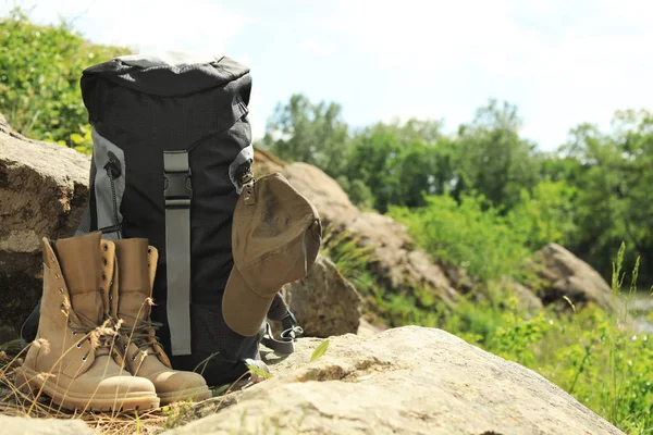 Rucksack und Campingausrüstung auf einem großen Stein in der Wildnis. Raum für Text — Stockfoto