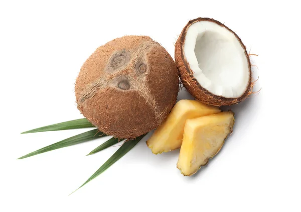 Chutné surové ananasové plátky, kokosové a listí na bílém pozadí, pohled shora — Stock fotografie
