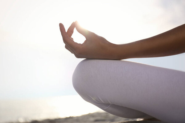 Young woman practicing zen meditation on beach, closeup. Space for text