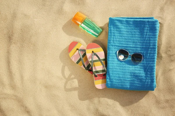 Flat lay composition of beach objects and towel on sand, space for text — Stock Photo, Image