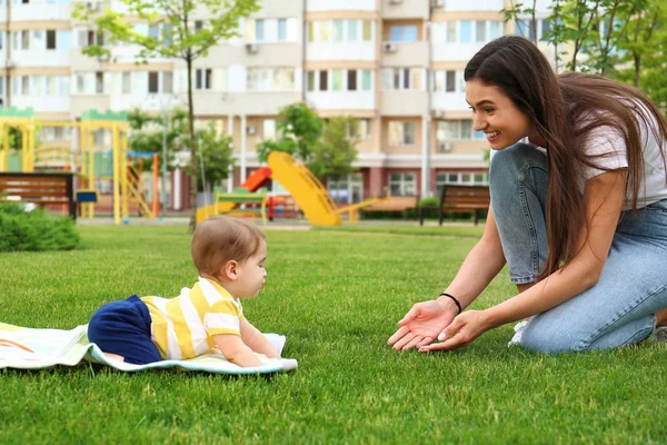 Adorável pequeno bebê rastejando para a mãe ao ar livre — Fotografia de Stock