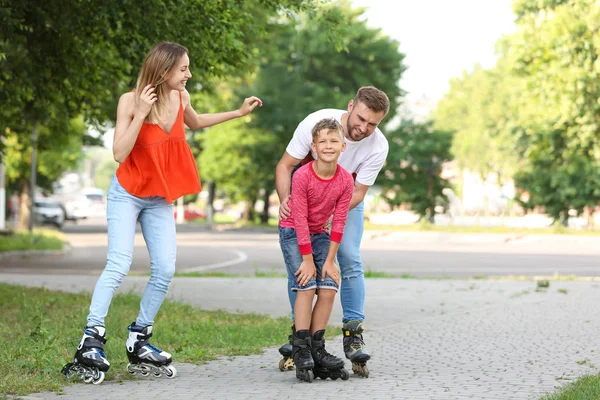 Jovem feliz família patinação rolo na rua da cidade — Fotografia de Stock