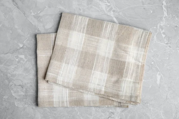 Açık mermer arka plan üzerinde Bej ekose mutfak havluları, üst görünümü
